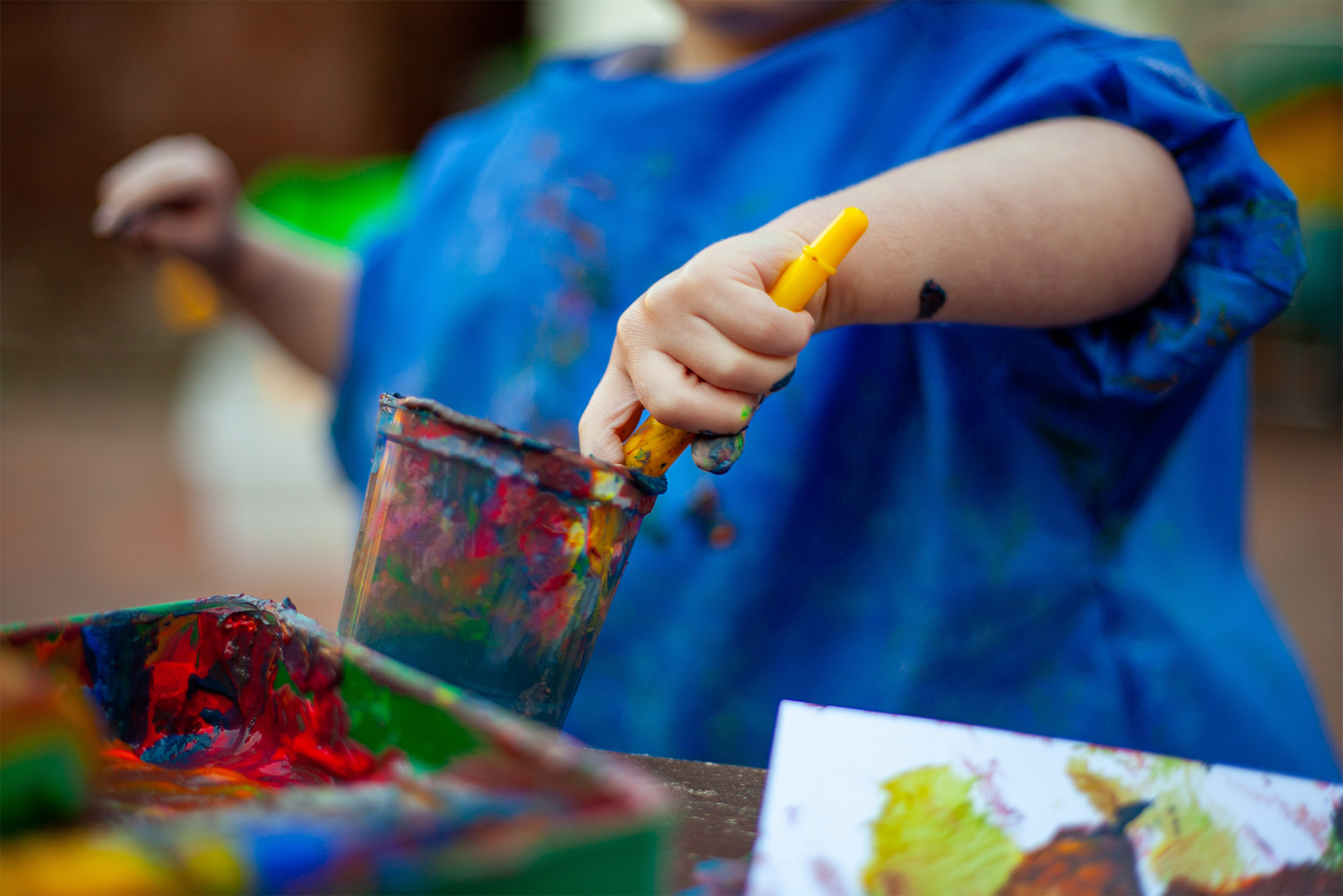 Young Child With Paint Brush In Pot